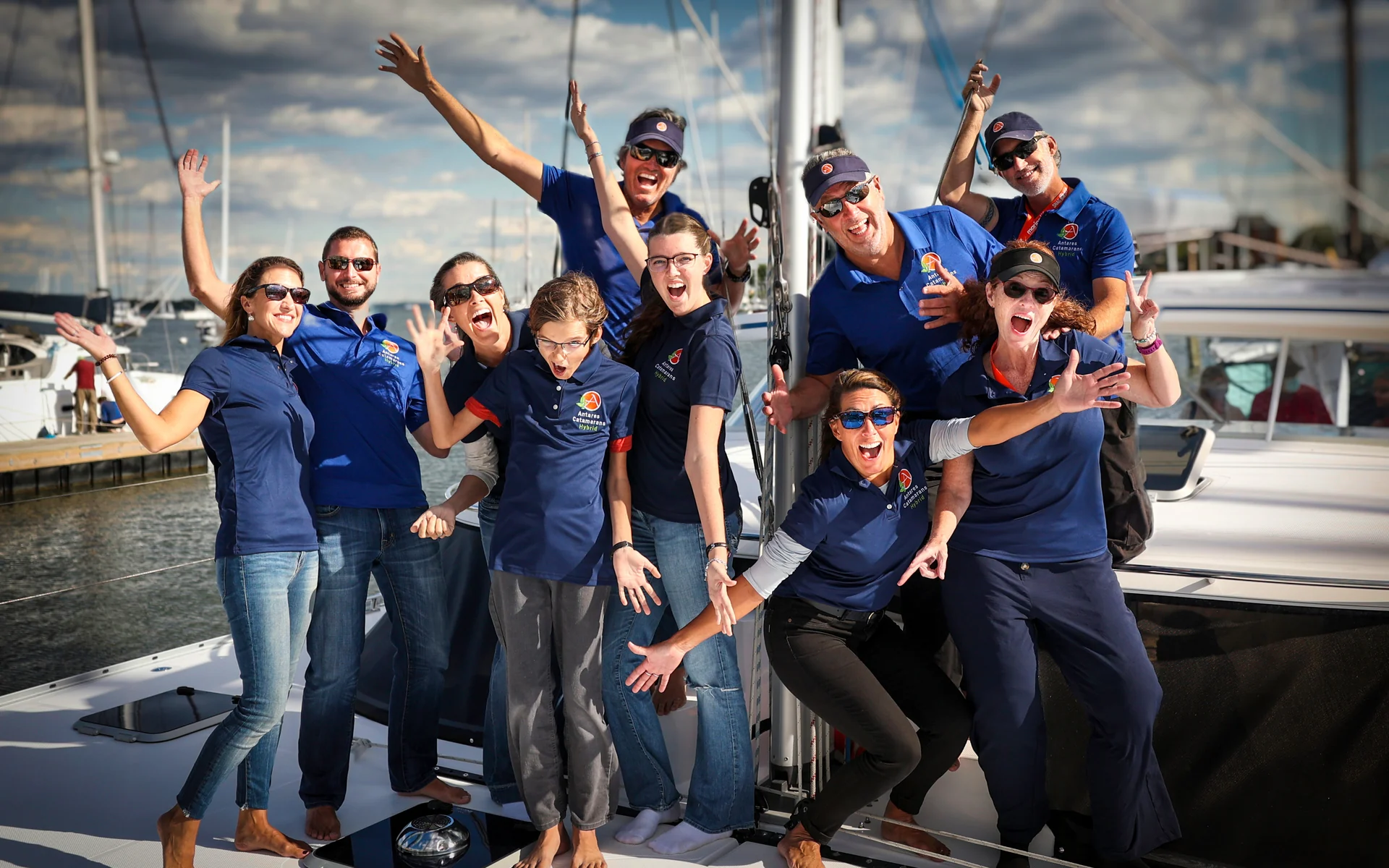 Antares owners and team members smiling aboard an Antares catamaran at the dock