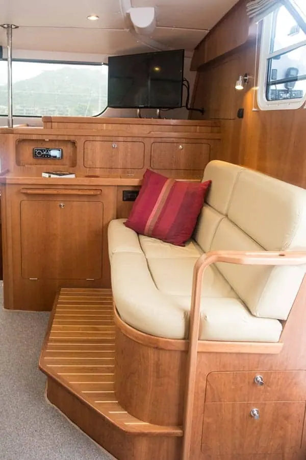 Antares 44 GS forward settee with cherry cabinetry and cream upholstery