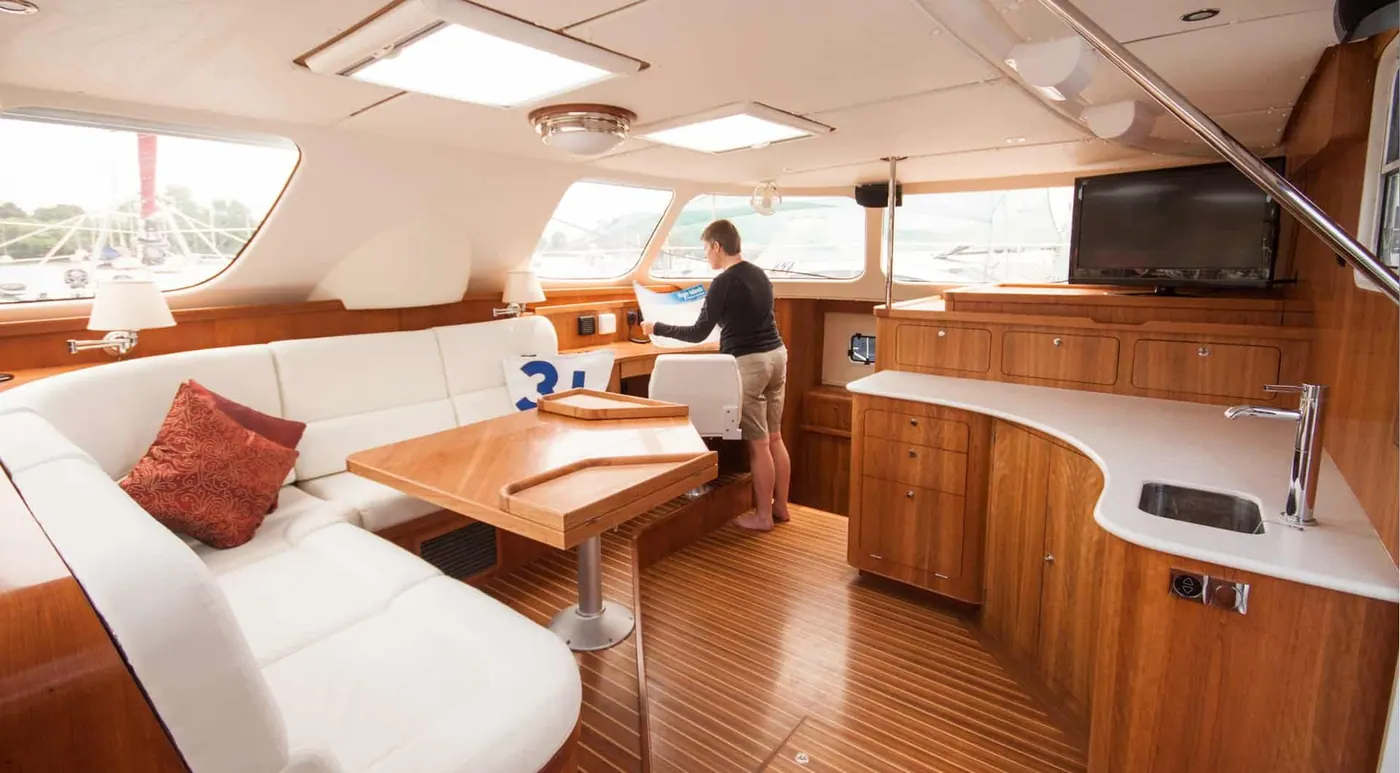 Antares 44 GS saloon woodwork with dining table and owner aboard
