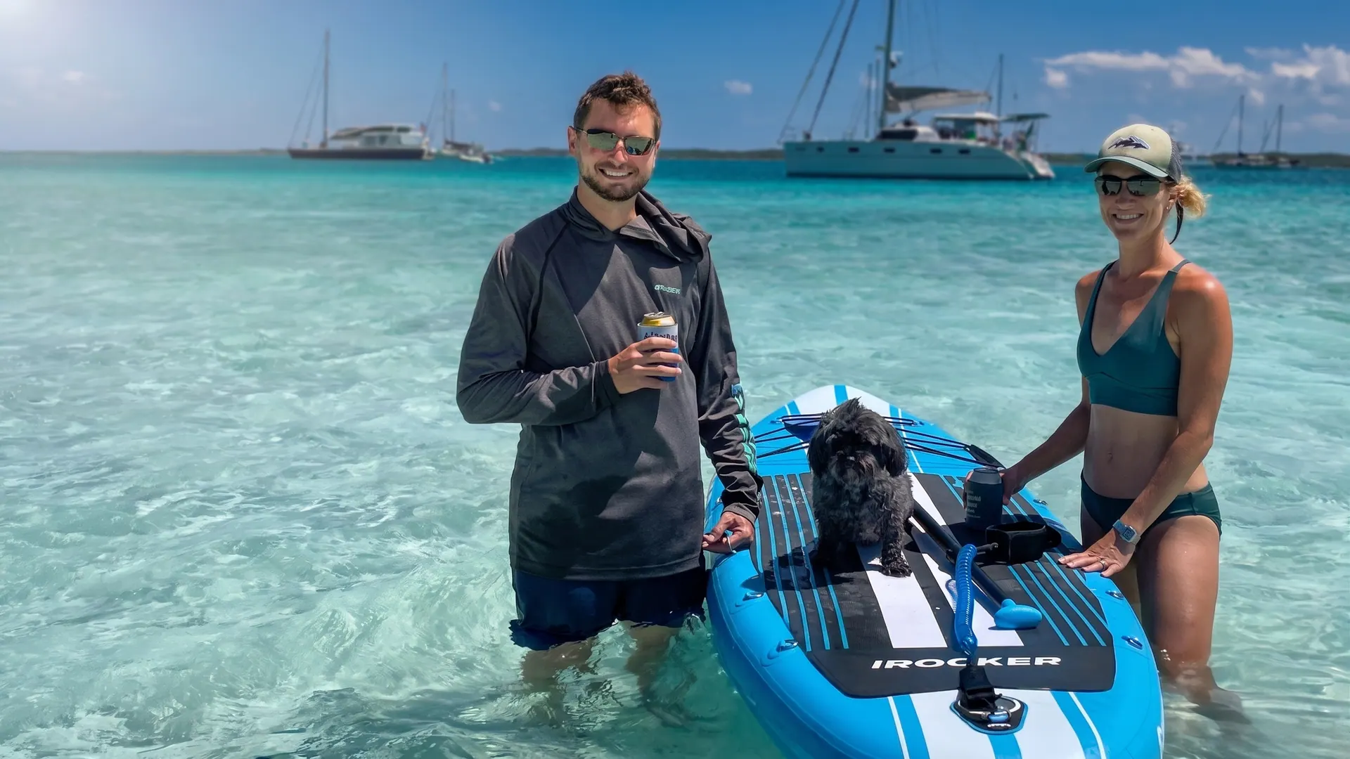 Antares owners with their dog on a paddleboard beside the yacht
