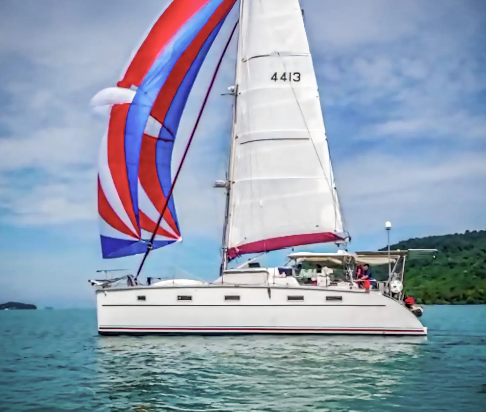 Whatabout PDQ Antares 44 sailing with red and blue spinnaker