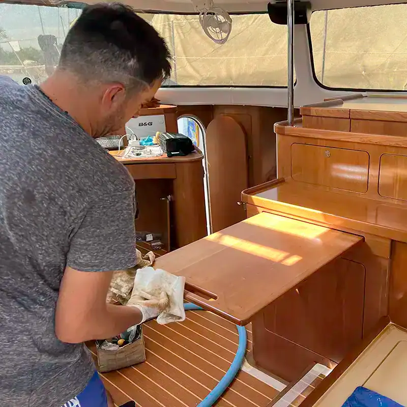 Craftsperson finishing cherry cabinetry in an Antares liveaboard interior