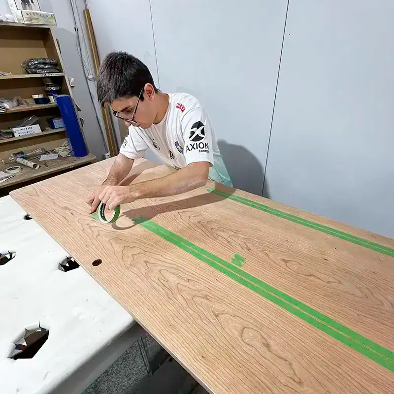 Craftsperson cutting cherry paneling for an Antares handcrafted interior