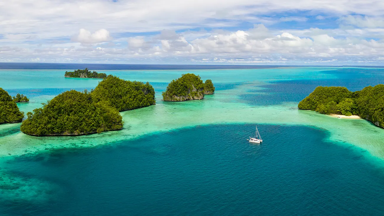 Antares catamaran anchored among remote tropical islands with protected rudders